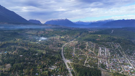 aerial drone view of a remote green valley surrounded by mountains, capturing the beauty of untouched nature