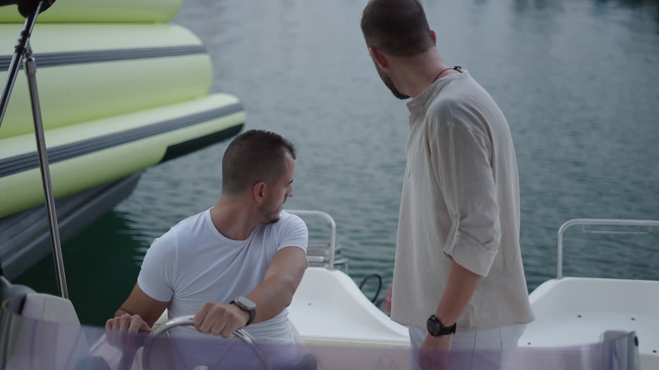 Two men on a boat at a marina having a discussion