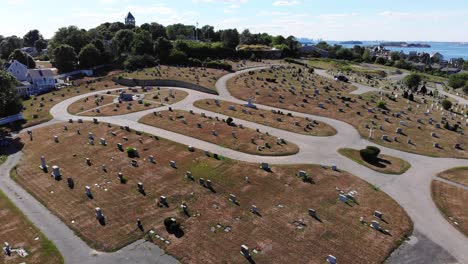 a drone pullback over a cemetery resulting in a view of boston in the distance over the harbor and ocean