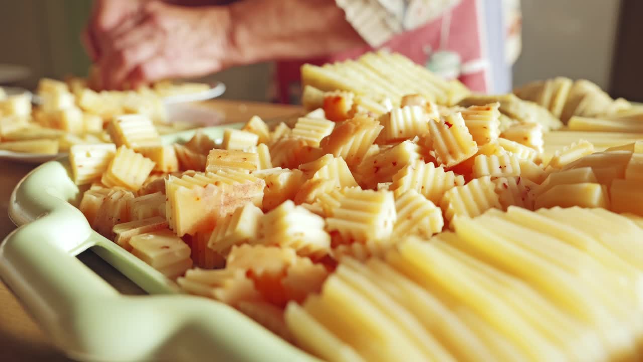 Idoso preparando uma tábua de queijos para a mesa, demonstrando carinho e tradição