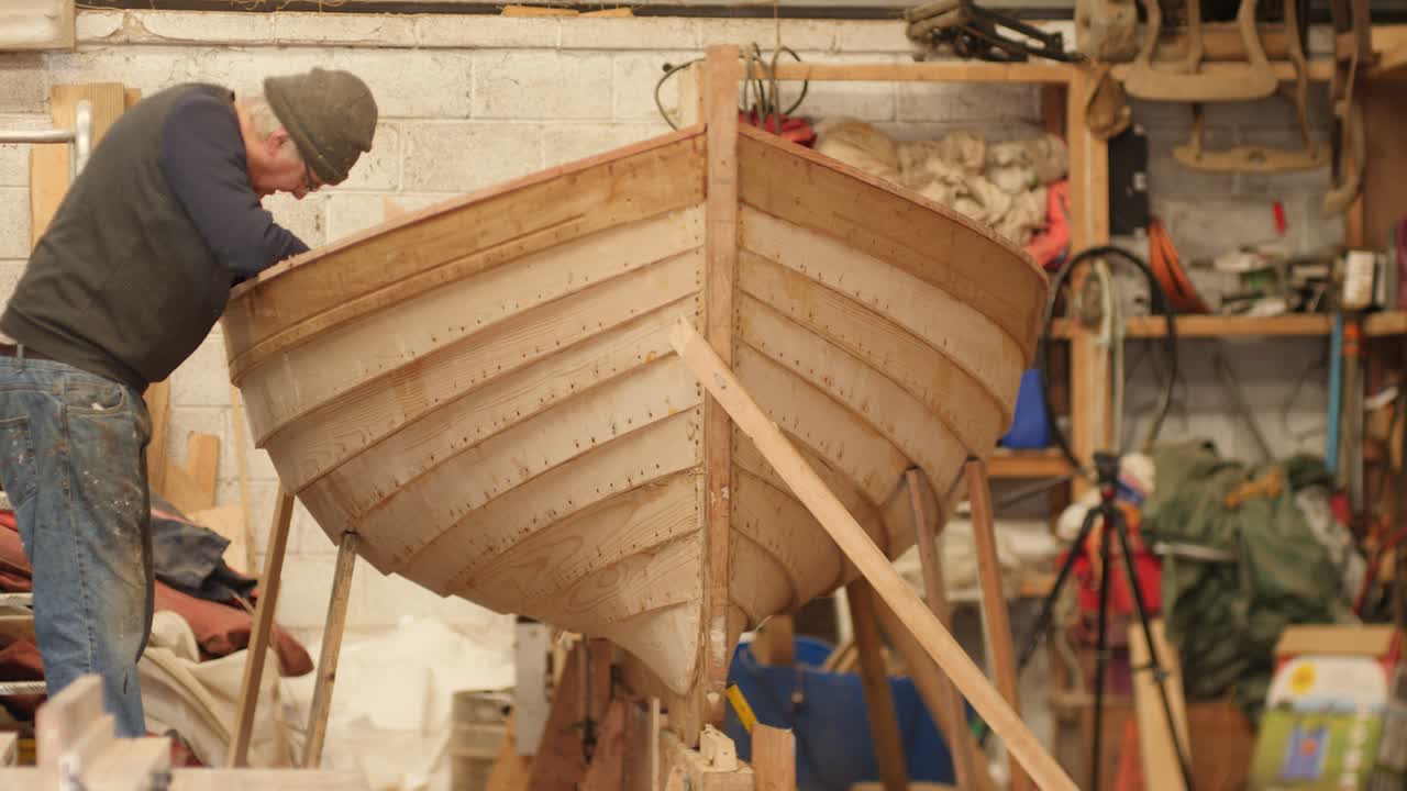 Boat builder working on clinker lapstrake dinghy boat