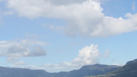 a serene view of rolling hills beneath a sky dotted with fluffy clouds.