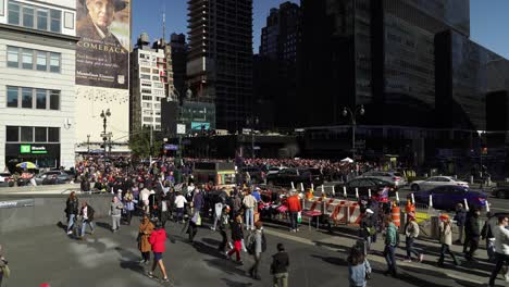 the crowd near madison square garden is filled with trump supporters, the sunlight highlighting their faces and signs