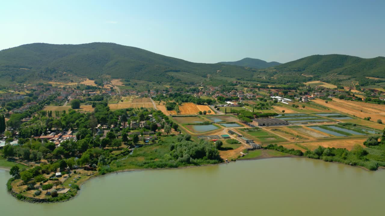 Castiglione del lago, a charming town on the shores of lake trasimeno in umbria, italy, showcases a harmonious blend of aquaculture and agriculture nestled amidst a picturesque landscape