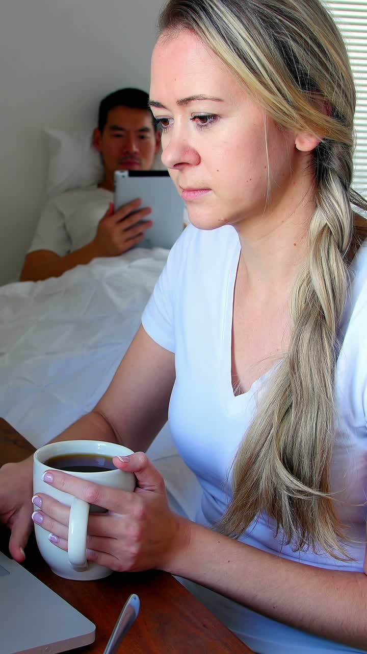 Woman using laptop while man using digital tablet
