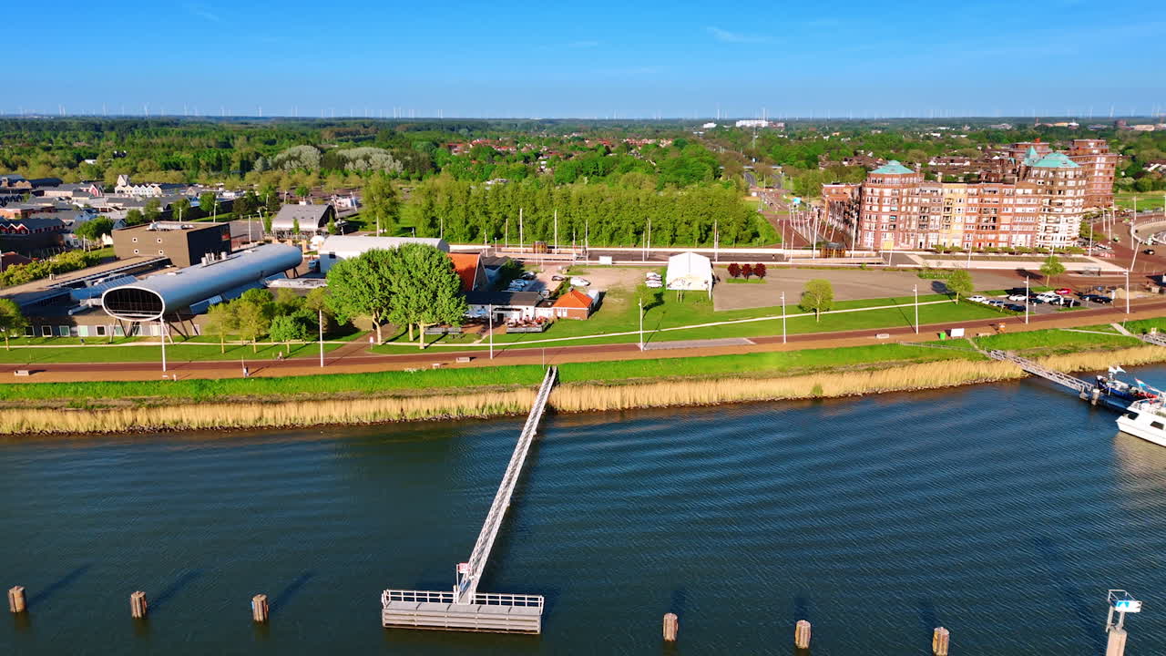 Green waterfront of beautiful Lelystad, the Netherlands. Drone footage above the waterscape of lake Markermeer revealing view on the port.