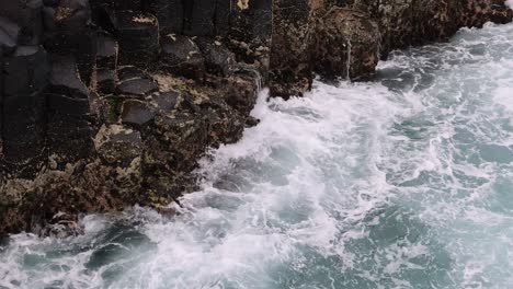 dynamic ocean waves hitting against a rugged coastline