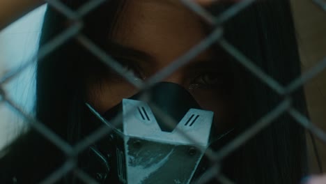 woman in cyberpunk mask behind fence