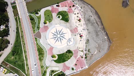 an empty children's playground with passing traffic and brown murky ocean after flash floods in dili, timor leste, south east asia - birdseye aerial drone