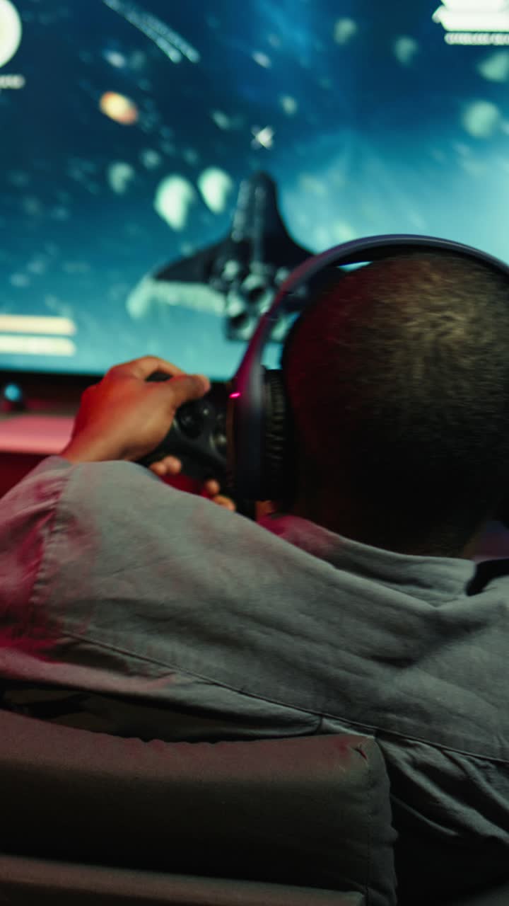 Vertical video Man playing entertaining spaceship flying videogame on large smart TV