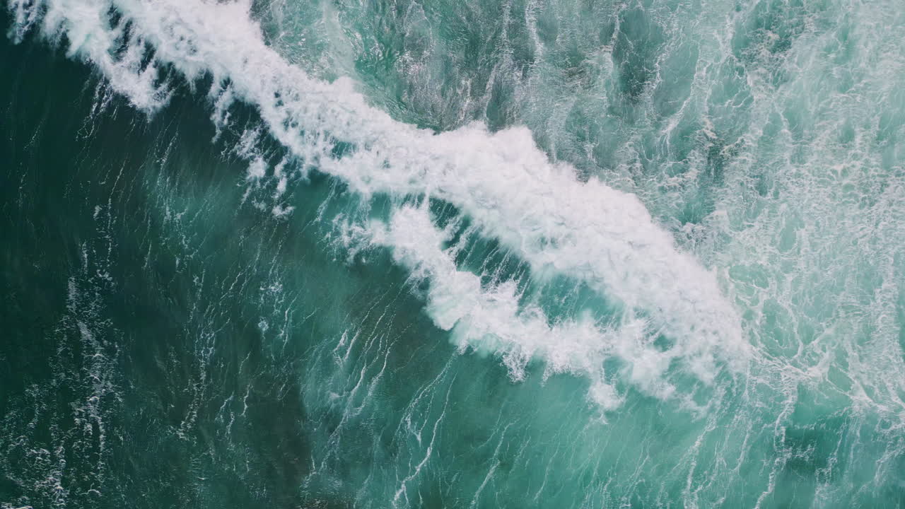 Top stormy sea surface waving with white foam slow motion. Aerial ocean waves