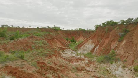 fly over the red volcano soil canyon with pants - long shot