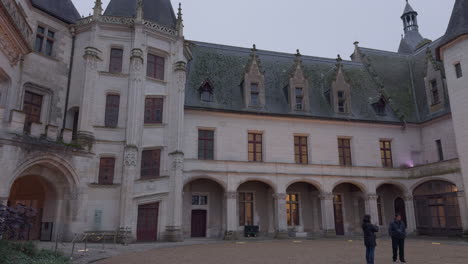historic french château with gothic spires and stone walls captured on a cloudy day