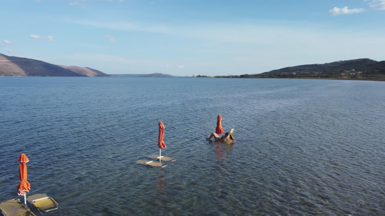 Woman lying on a sun lounger in Three Umbrellas, Greece