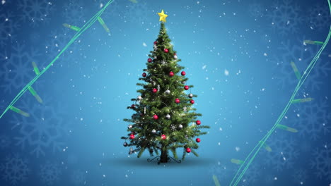 luces de cuerda amarillas parpadeando sobre el árbol de navidad decorado y la nieve cayendo sobre un fondo azul