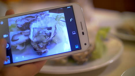 Tomando-Fotos-De-Ostras-Con-Un-Teléfono-Inteligente