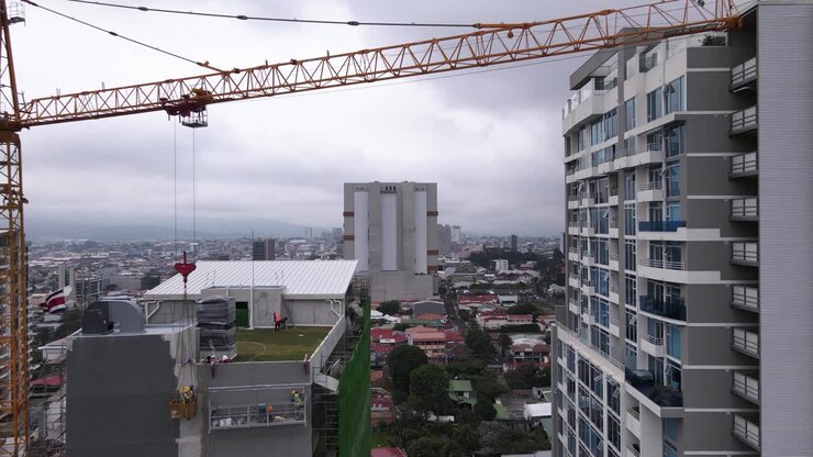 Toma de dron volando por debajo de una grúa y un rascacielos en San José, Costa Rica