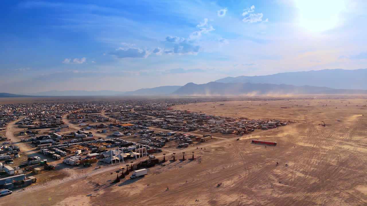 Burning Man City al tramonto. Vista aerea della città sulla spiaggia e dei campeggi illuminati dalla calda luce del tramonto