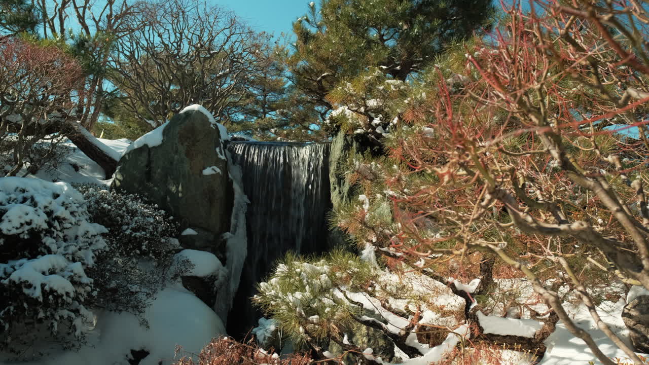 겨울 화창한 날에 작은 폭포의 느린 랙 초점 공개