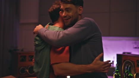 cheerful friends greeting home party close up. excited men hugging meeting