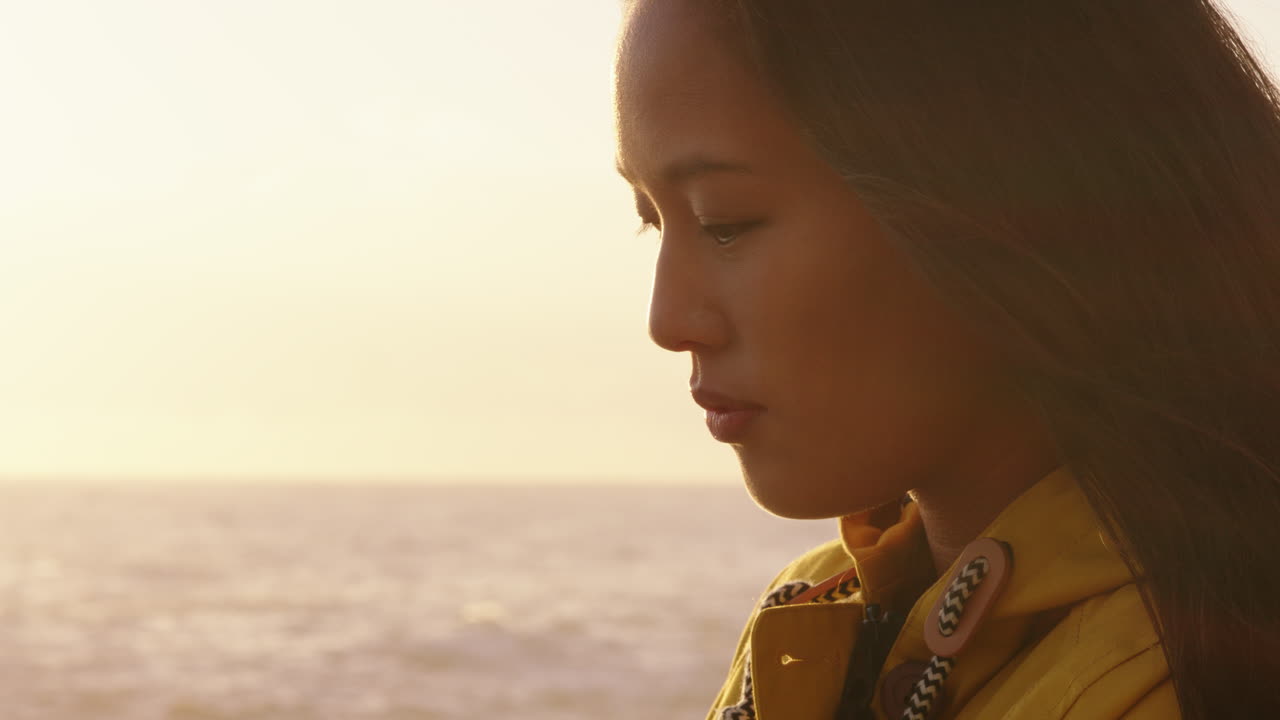 아름다운 아시아 여성의 초상화 해가 지는 해변을 즐기고 영성을 탐험하고 기도하고 여행을  ⁇ 상하고 해변에서 휴식을 취하고 있습니다.