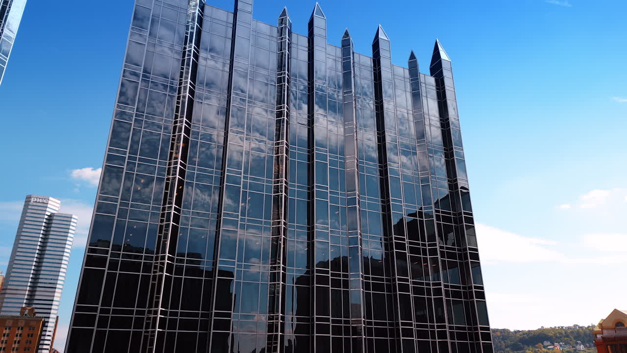 Pittsburg, USA, 14 August 2025: Mirror façade of the building reflects blue sky with clouds. Low angle view at One PPG Place in the downtown of Pittsburg, Pennsylvania, USA