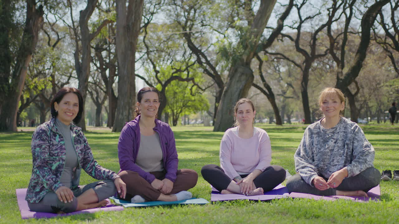 mujeres practicando yoga en un parque