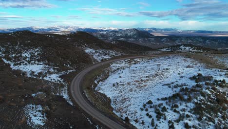 vista aérea de drones de una gran carretera de flexión entre montañas y nieve