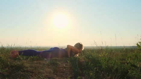 woman practicing yoga in a field at sunrise
