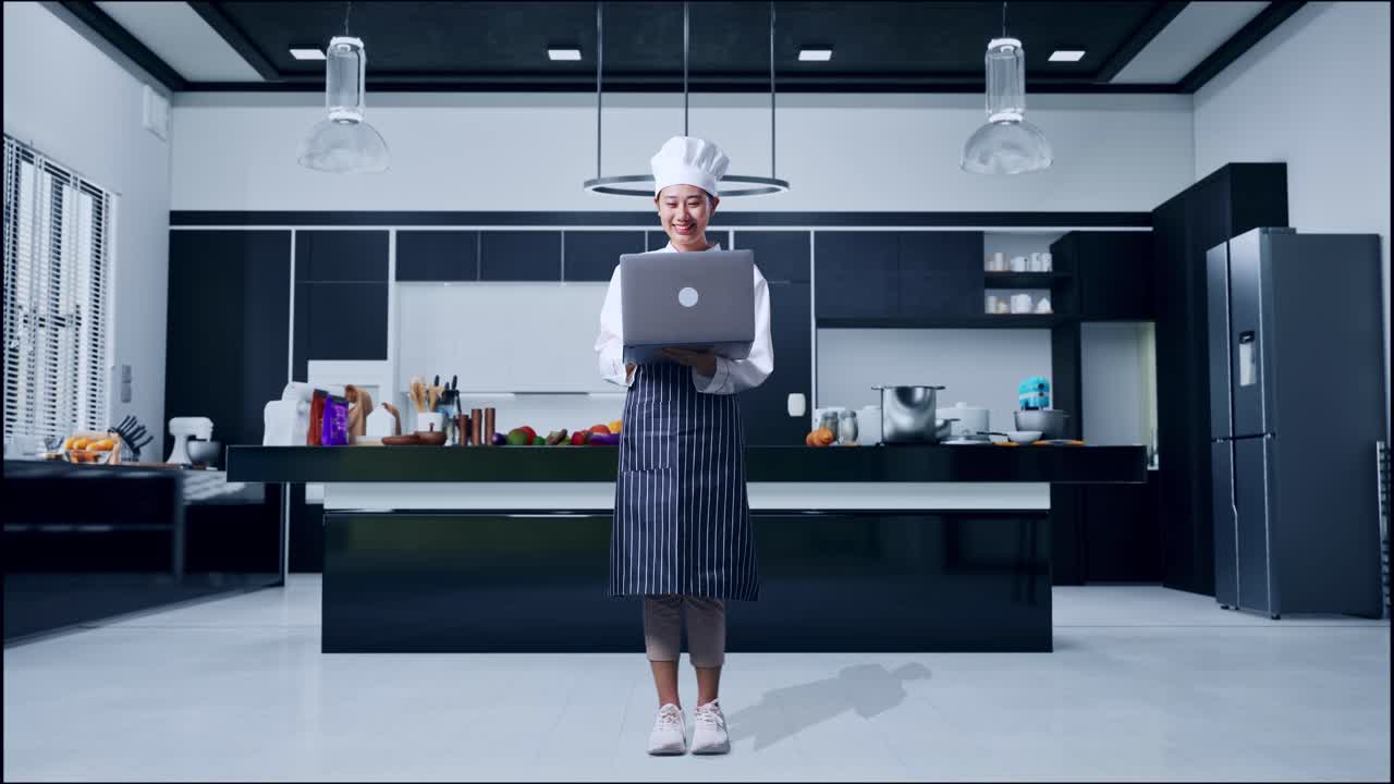 mujer chef usando una computadora portátil en una cocina moderna