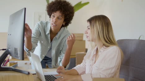 dos mujeres jóvenes trabajando juntas en la oficina, revisando el pedido del cliente