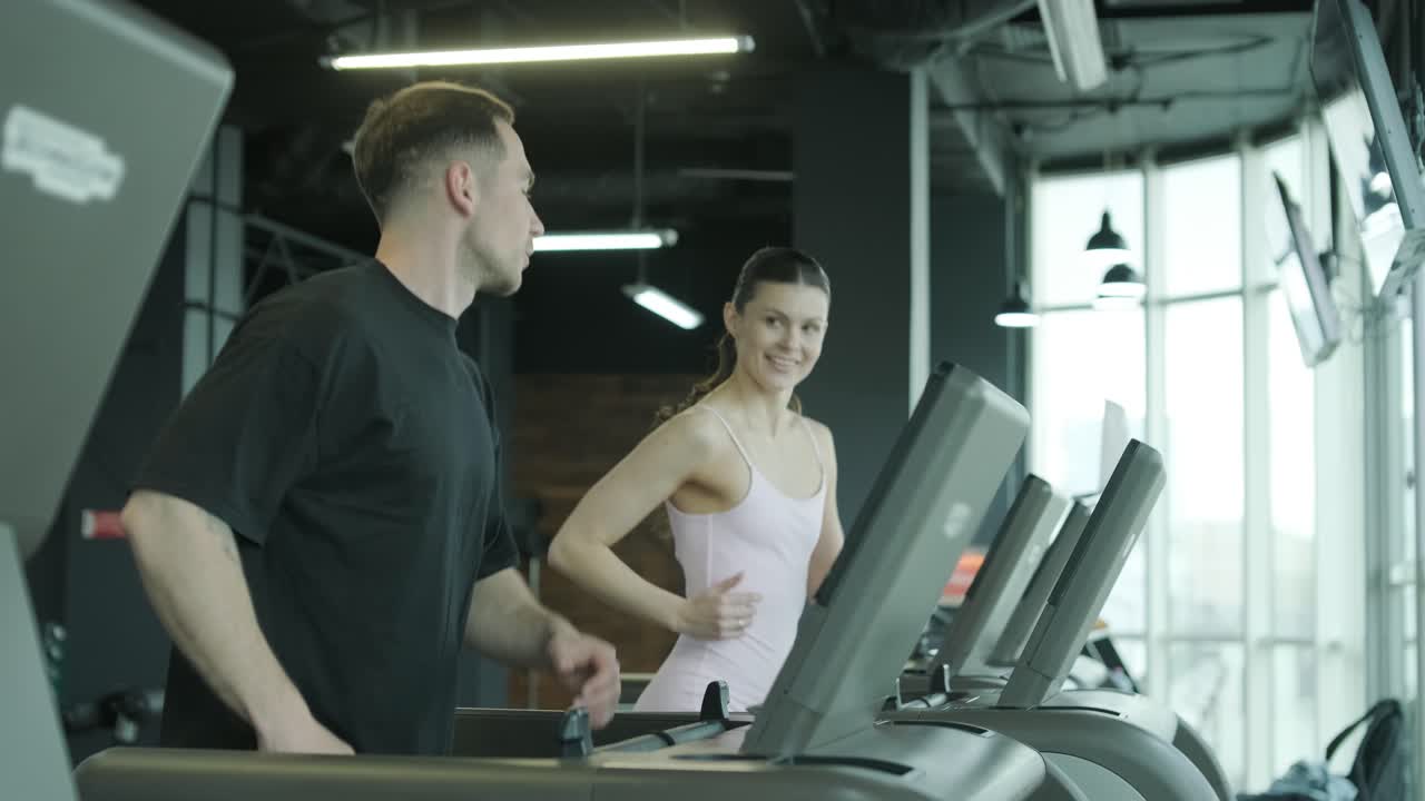 Coppia che si allena sui tapis roulant in palestra