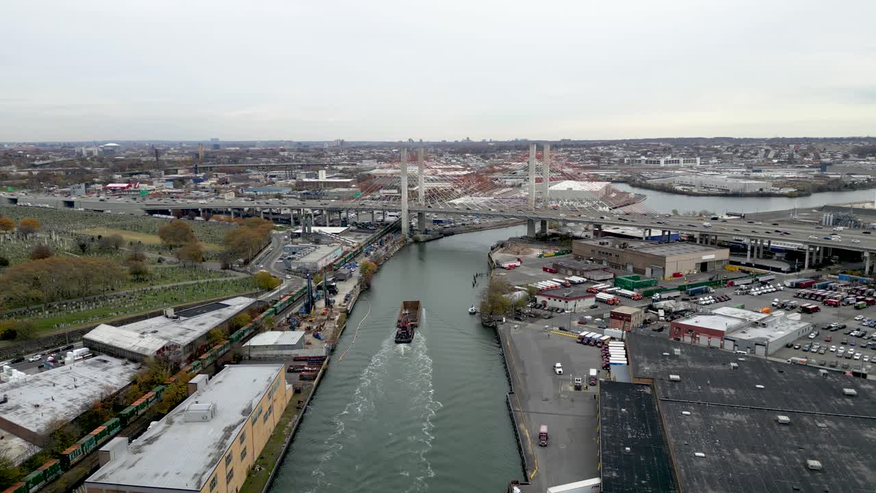 Drone circles Bronx–Whitestone Bridge at sunset, showcasing the golden sky, tranquil water, and the iconic span with NYC skyline in the background during golden hour. Ideal for stock footage