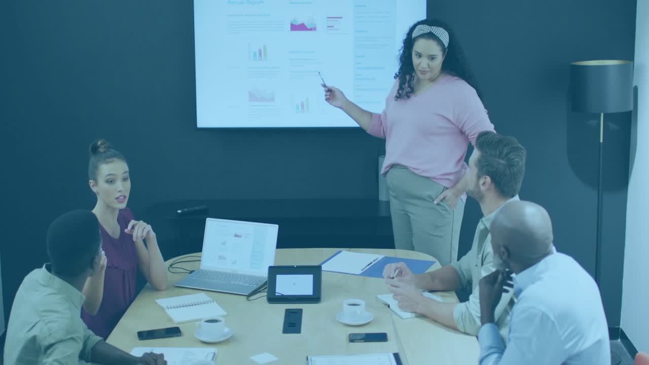 Presenter clicking remote pointing at bar chart in tech briefing while clear code overlay scrolling