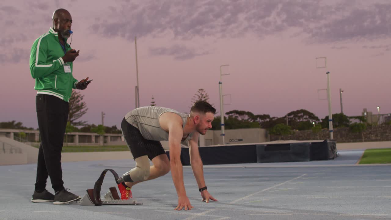 다양한 남성 코치와 장애인 선수가 일몰 때 달리기 블레이드 훈련을 하고 있습니다.