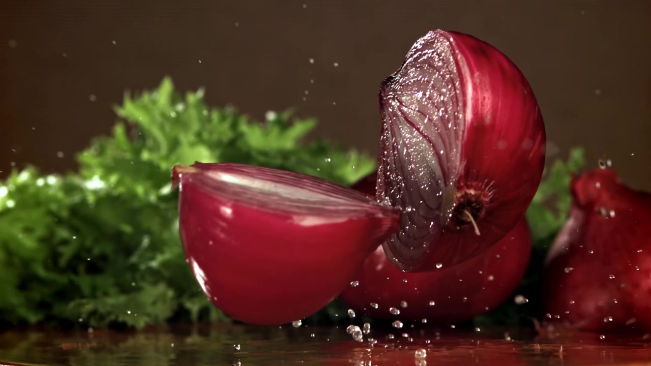 Red Onion Falling and Splitting in Slow Motion with Water Splashes