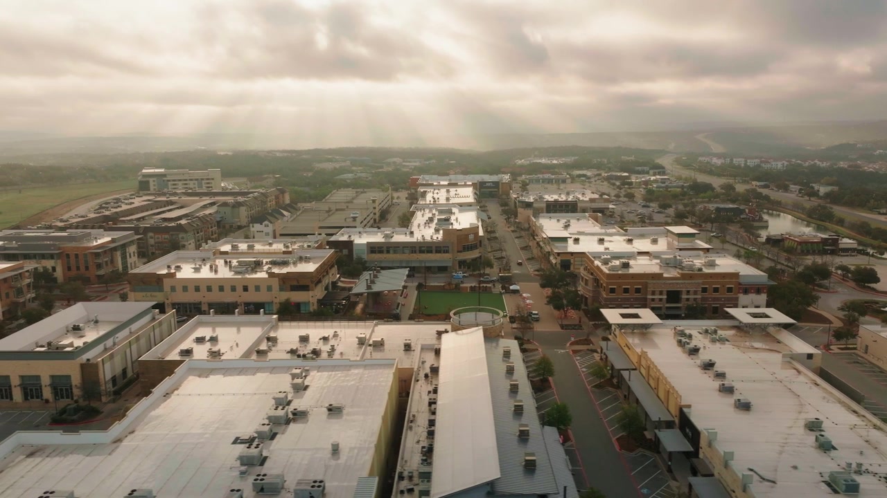 Austin, Texas Hill Country Galleria mall and neighborhood community shopping center aerial drone flyover pan at sunrise