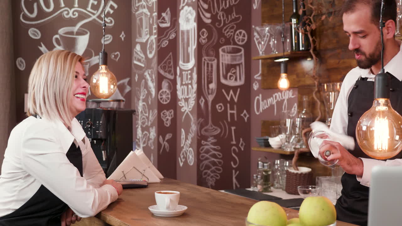People in a coffee shop, served by a barista