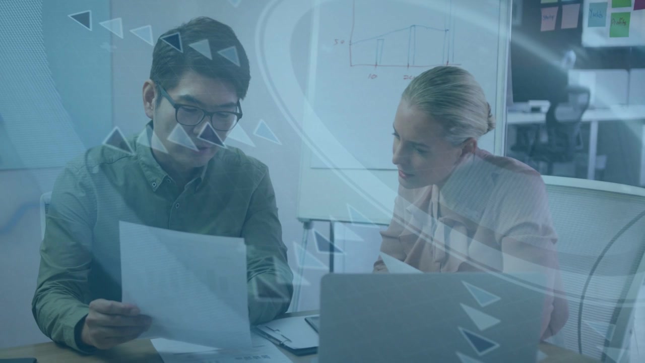 Man flipping report, woman leaning over laptop, triangular overlay sweeping for business review