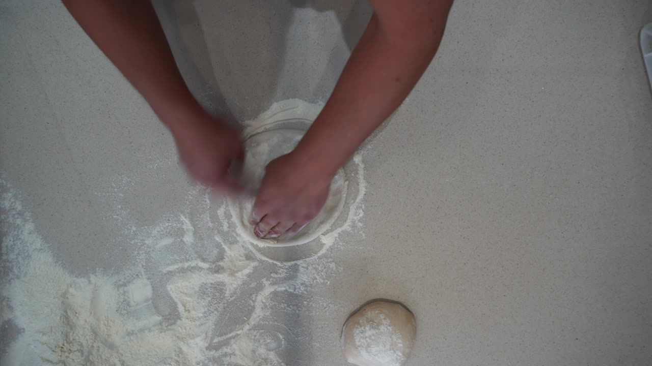 반죽 공에서 평평한 피자 반죽을 만드는 요리사의 오버헤드 뷰. 피자 을 만드는 셰프의 위아래 뷰