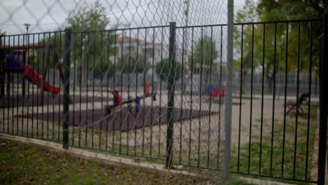 Closed-and-sealed-playground-during-coronavirus-lockdown,-view-through-a-wired-fence