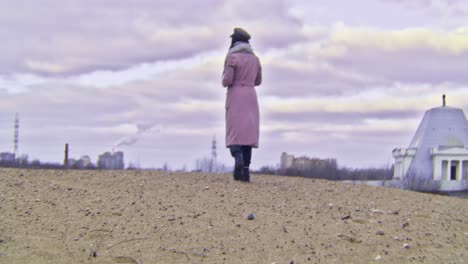 woman in pink coat on a hilltop