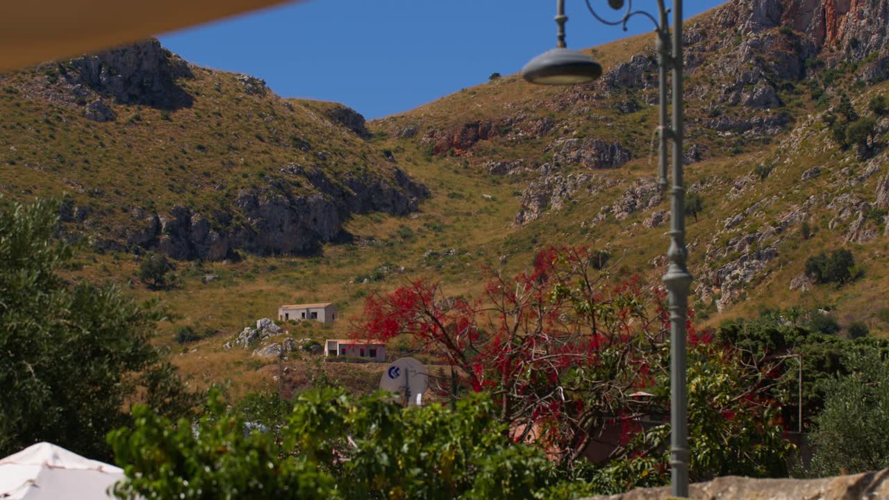 Scopello city center with hills under a clear blue sky in Sicily, Italy