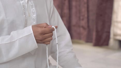 closeup of indian man hand praying beads