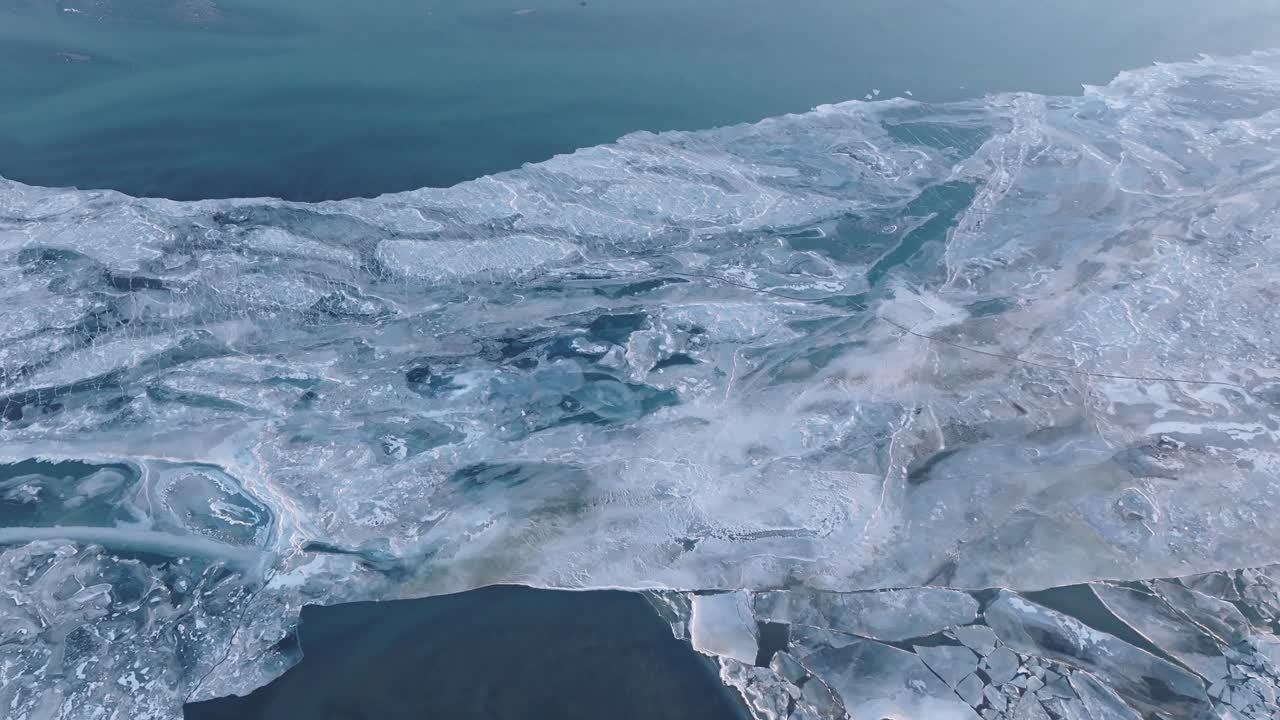 Splendide riprese aeree di lastre di ghiaccio glaciale che si fondono con l'acqua blu profondo dell'oceano lungo la costa dell'Islanda meridionale. Texture ghiacciate astratte e motivi di ghiaccio vorticosi creano una scena naturale mozzafiato.