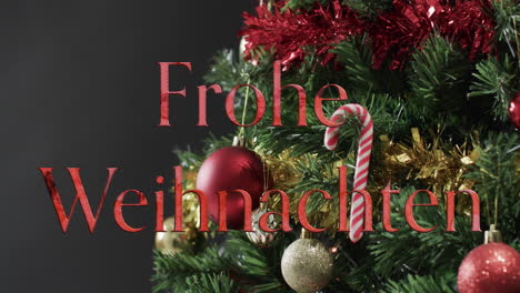 frohe weihnachten text in red over decorated christmas tree on black background