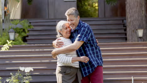 Happy-biracial-senior-couple-embracing-in-sunny-garden