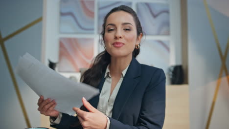 smiling businesswoman greeting videocall office closeup. coach holding documents