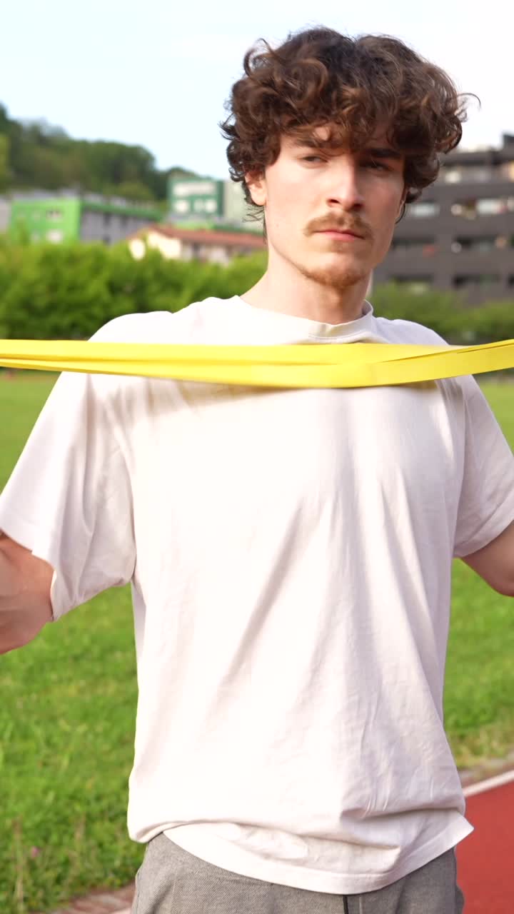 Man exercising with resistance band on track