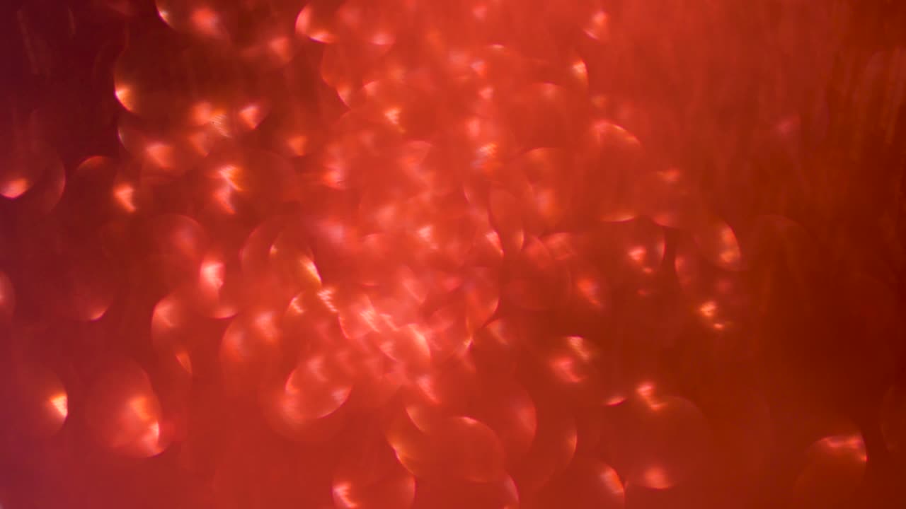 Red Glitter , abstract bokeh background , elegant of Christmas dust . shiny sparkling particles . light glittering motion movement .